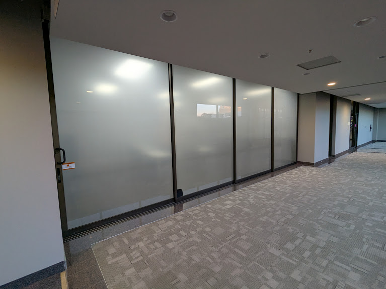 Office corridor with frosted glass partitions in dark frames