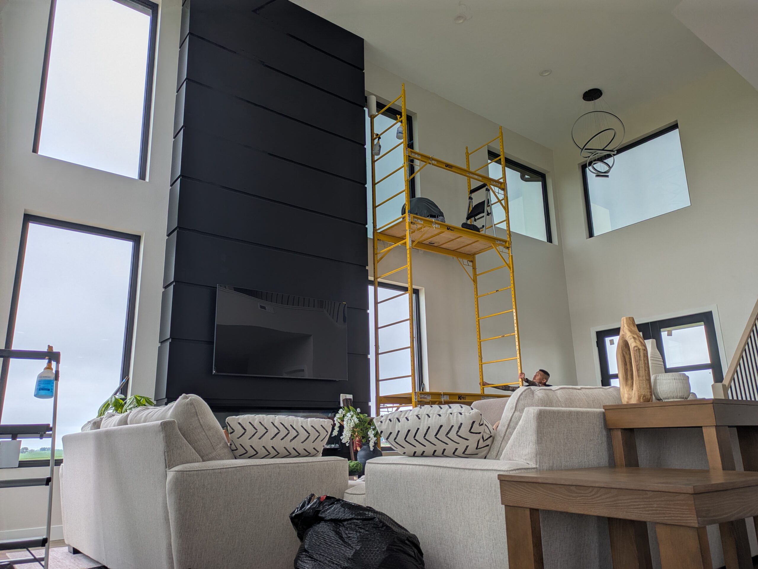 Living room with tall windows and scaffolding during installation