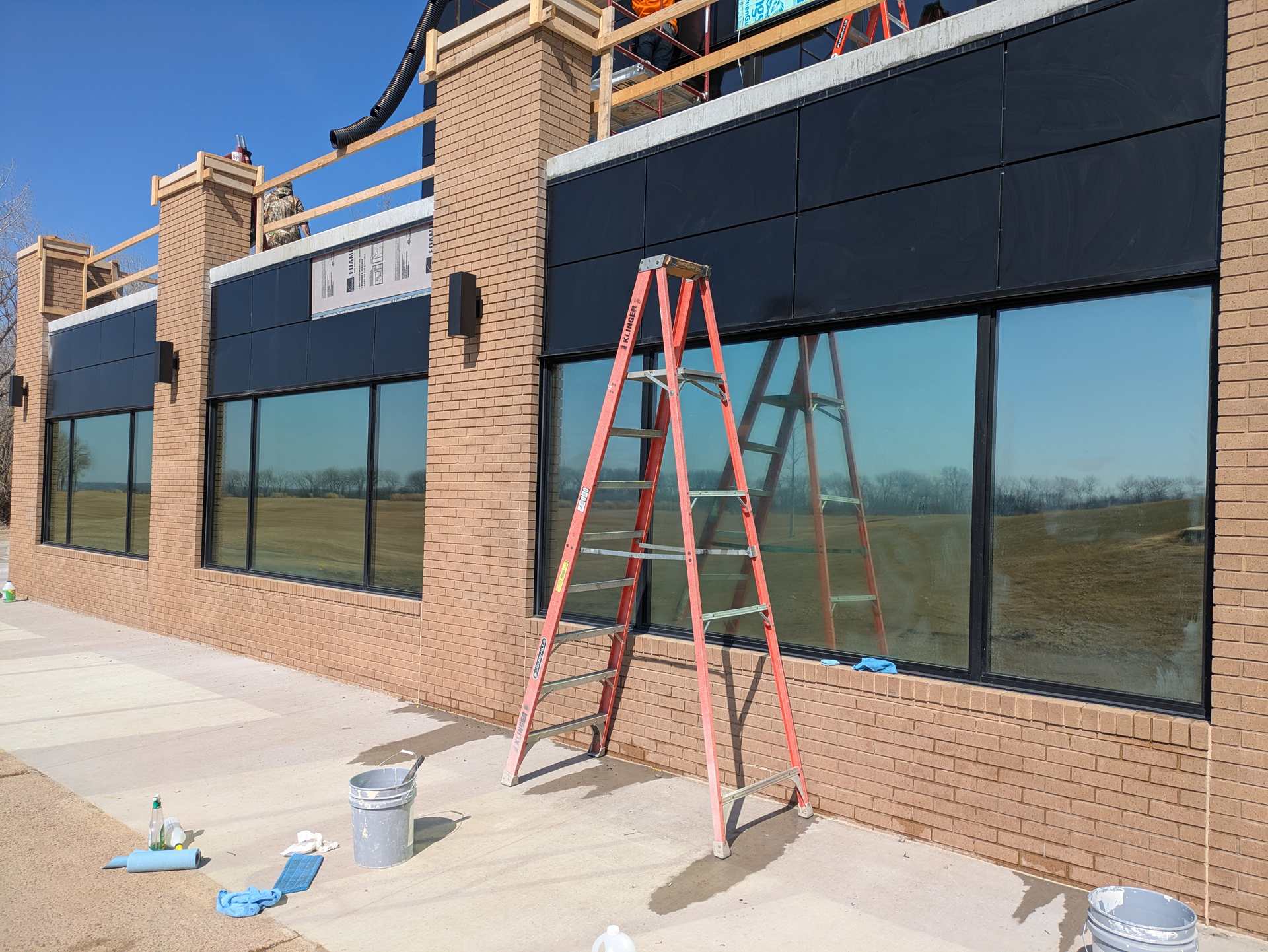 Brick commercial building in Dakota Dunes with large exterior windows during window film install