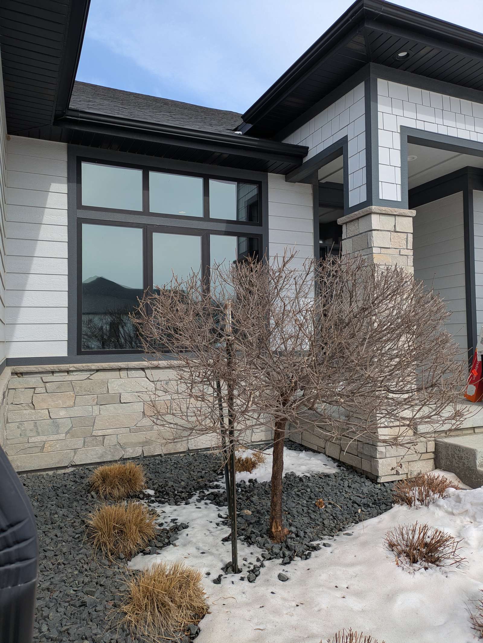 Home entrance with tall black-framed windows in Dakota Dunes